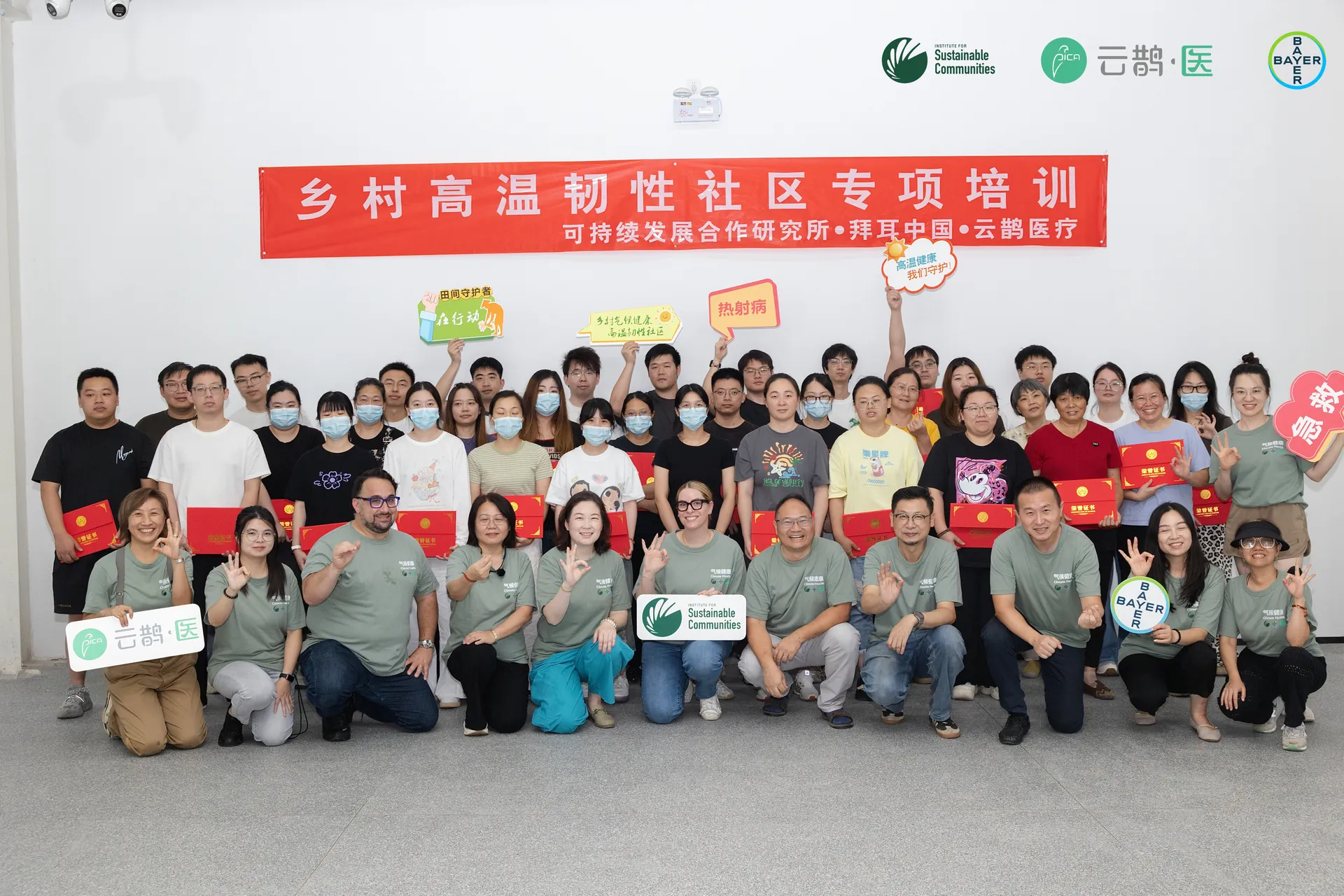 Community participants and programme partners gathered beneath the training banner