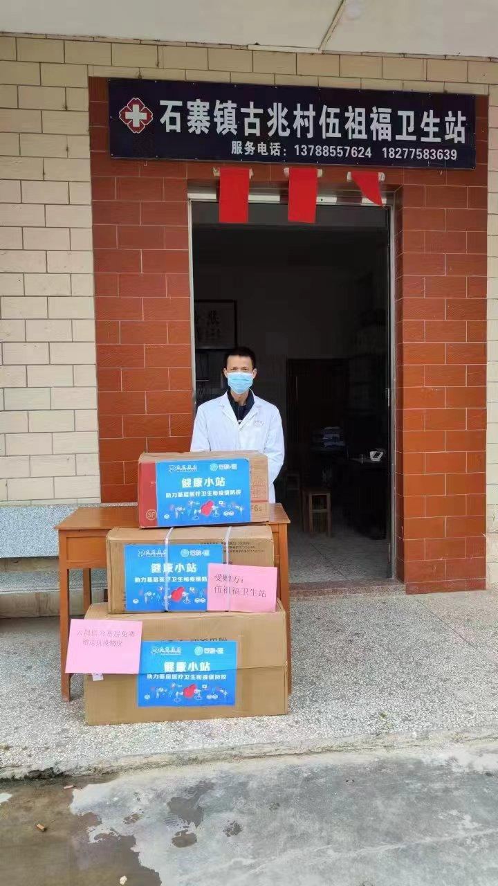 A village doctor receives health-station supplies at the entrance of his village health station